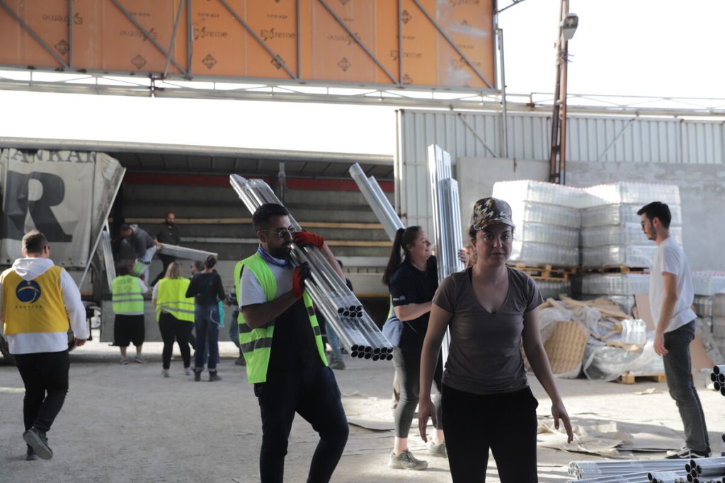 People carrying aid items off of trucks