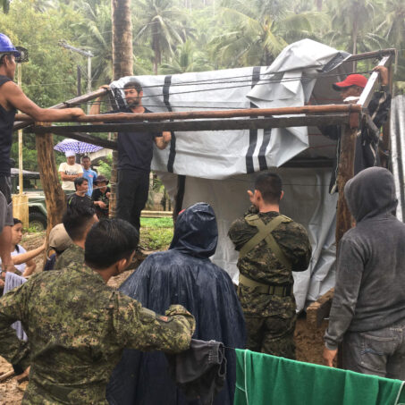 People building shelter after tropical storm on the Philippines