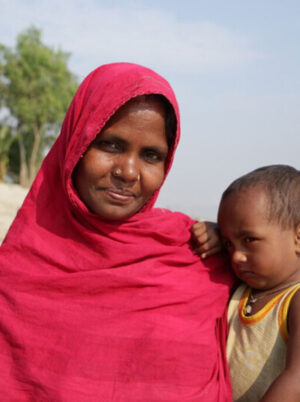 Woman in a bright red scarf with a child in her arms