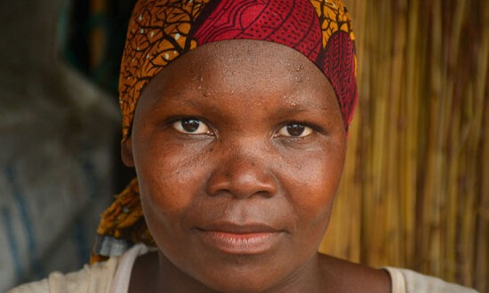 Portrait of a woman wearing a red and orange head scarf