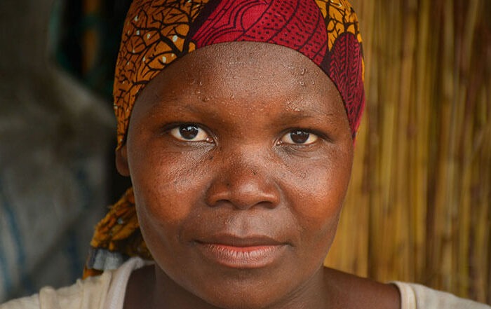 Portrait of a woman wearing a red and orange head scarf