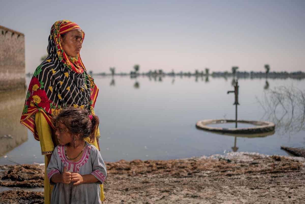 Lady and child standing in front of flooded land