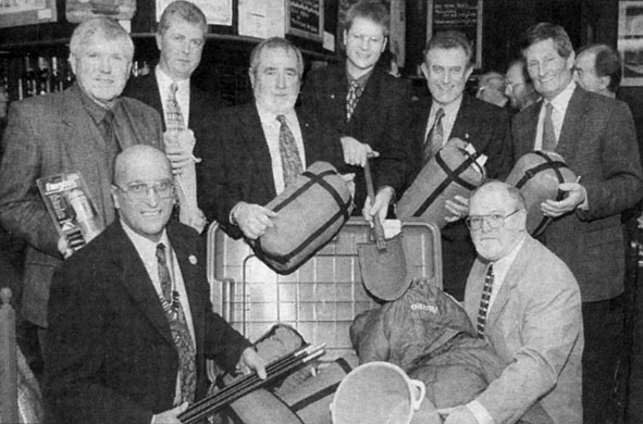 Black and white photo of men holding pieces of aid