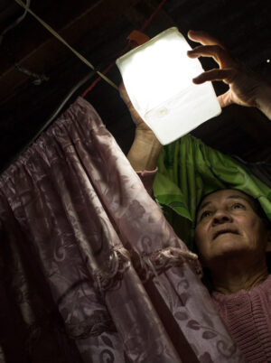 Woman hangs solar light up in paraguay