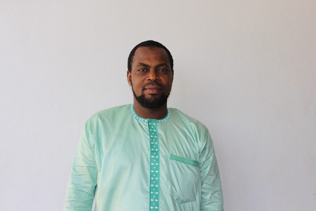 Man wearing green smiling at the camera