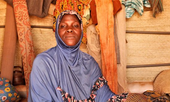 Woman wearing light blue headscarf in a shelter in Burkina Faso