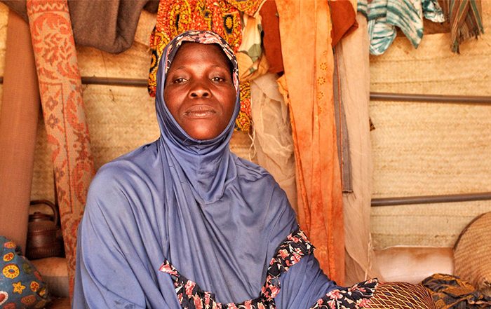 Woman wearing light blue headscarf in a shelter in Burkina Faso