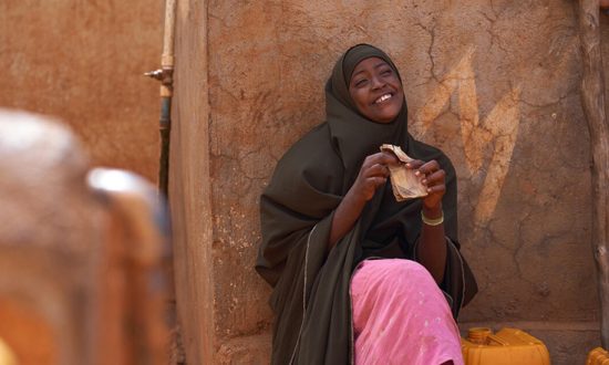 Woman smiling next to a shelter in Somalia