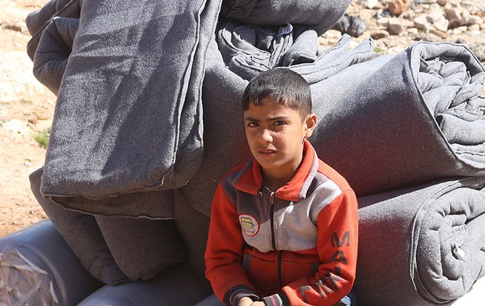 Boy sitting on pile of blankets