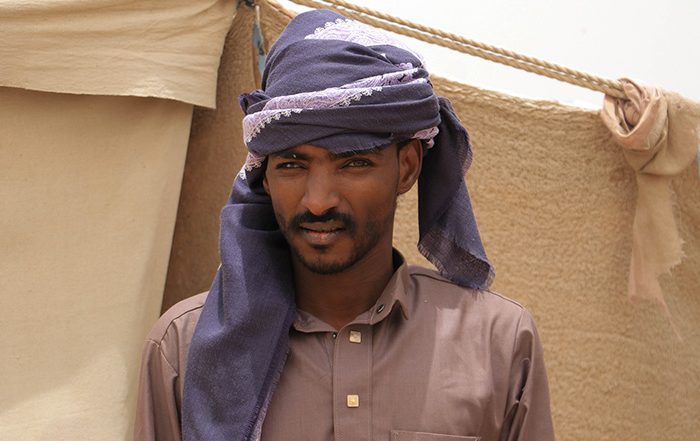 Man wearing purple head turban outside tent in Yemen