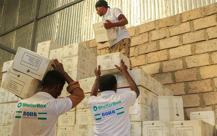 People stacking boxes of aid in a warehouse